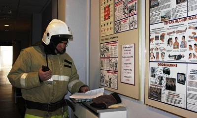 Пожарный у стенда по безопасности